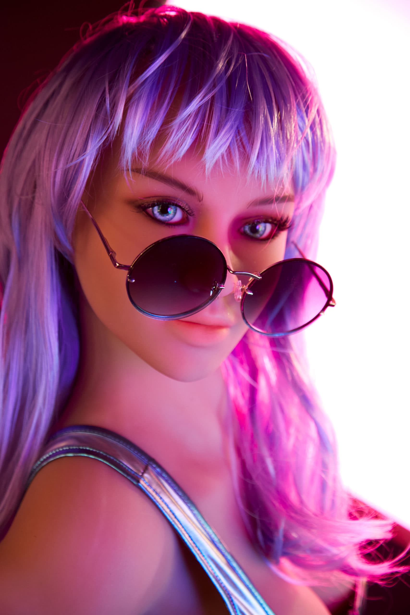 Close-up of TPE sex doll Techno Babe with purple hair, sunglasses, and metallic outfit in vibrant neon lighting